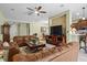 Spacious living room with brown leather furniture, ceiling fan, and open floor plan to the kitchen at 4402 Natures Reach Ter, Parrish, FL 34219
