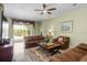 Comfortable living room featuring leather furniture, ceiling fan, and sliding glass doors to the outdoor space at 4402 Natures Reach Ter, Parrish, FL 34219