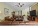 Comfortable living room featuring an open layout, tan walls, a ceiling fan, and a television at 4402 Natures Reach Ter, Parrish, FL 34219