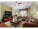 Inviting living room with an open layout, tan walls, a ceiling fan, and a television at 4402 Natures Reach Ter, Parrish, FL 34219