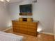 Bedroom features a dresser with a wall-mounted television and tiled flooring at 4607 W North B St # 105, Tampa, FL 33609