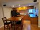 Eat-in kitchen with a table, wooden cabinets, and black appliances at 4607 W North B St # 105, Tampa, FL 33609