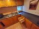 Kitchen with wooden cabinets, tiled backsplash, and black countertops at 4607 W North B St # 105, Tampa, FL 33609