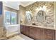 Beautiful bathroom featuring dual sinks, a luxurious tub, and brick-style tiling at 4818 88Th E St, Bradenton, FL 34211
