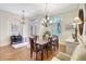 Bright dining room features a wood table, six chairs, a chandelier, and two windows with shutters at 4818 88Th E St, Bradenton, FL 34211