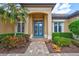 Close up of the beautiful glass front door with lush garden views and colorful flower beds at 4818 88Th E St, Bradenton, FL 34211