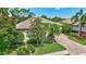 Single-story home with a tile roof, a brick driveway, and a lush lawn and landscaping at 4818 88Th E St, Bradenton, FL 34211