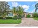 Beautiful home with paver driveway, lush lawn, manicured landscaping, and striking blue double-door entry at 4818 88Th E St, Bradenton, FL 34211