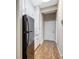 Hallway with clean lines, white cabinets, a refrigerator, and wood flooring at 4818 88Th E St, Bradenton, FL 34211