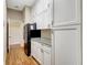 Pantry area with white cabinets, granite countertop, and black refrigerator at 4818 88Th E St, Bradenton, FL 34211