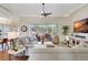 Comfortable living room featuring hardwood floors, ceiling fan, and large windows with view of the lanai at 4818 88Th E St, Bradenton, FL 34211