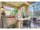 Outdoor kitchen with stainless steel grill, counter seating, and views of the landscaped yard at 4818 88Th E St, Bradenton, FL 34211