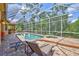 Relaxing screened pool and patio area with an in-ground pool, tiled patio, lawn chairs, and a jacuzzi at 4818 88Th E St, Bradenton, FL 34211
