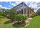 The side yard features lush landscaping surrounding the screened patio, complete with a tile roof at 4818 88Th E St, Bradenton, FL 34211