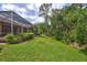 The side yard features a lush green lawn and landscaping around the screened patio at 4818 88Th E St, Bradenton, FL 34211