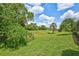 The backyard features lush, green grass, and palm trees at 4818 88Th E St, Bradenton, FL 34211