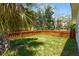 Fenced backyard showcasing a lush lawn with mature trees and a wood perimeter fence offering privacy at 515 N Osprey Ave, Sarasota, FL 34236