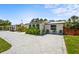 Inviting single-story home with a stylish paver driveway and lush tropical landscaping with decorative outdoor seating at 515 N Osprey Ave, Sarasota, FL 34236