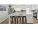Open-concept kitchen boasts white cabinets, stainless appliances, stylish backsplash, and spacious island at 515 N Osprey Ave, Sarasota, FL 34236