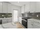 Bright kitchen with white cabinets, stainless steel appliances, quartz countertops, and wood-look flooring at 515 N Osprey Ave, Sarasota, FL 34236