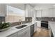 Bright kitchen featuring stainless appliances, a gray backsplash, and white cabinets and quartz countertops at 515 N Osprey Ave, Sarasota, FL 34236