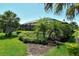 Green backyard featuring a screened-in pool and tropical landscaping at 5968 Snowy Egret Dr, Sarasota, FL 34238