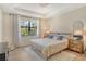 Bright bedroom featuring neutral décor, a large window, and elegant furnishings at 5968 Snowy Egret Dr, Sarasota, FL 34238