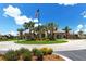 Beautiful clubhouse with lush landscaping, palm trees, and a striking American flag at 5968 Snowy Egret Dr, Sarasota, FL 34238