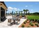 Outdoor grilling area with tables, chairs, and lush landscaping at 5968 Snowy Egret Dr, Sarasota, FL 34238