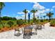 Inviting outdoor seating area with tables, chairs, and umbrellas surrounded by lush landscaping at 5968 Snowy Egret Dr, Sarasota, FL 34238
