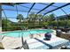 Inviting screened-in pool area with palm trees and a dining table ready for entertaining at 5968 Snowy Egret Dr, Sarasota, FL 34238