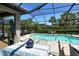 Inviting screened-in pool area with palm trees and a dining table ready for entertaining at 5968 Snowy Egret Dr, Sarasota, FL 34238