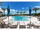 Resort-style pool with lounge chairs, umbrellas, and palm trees, perfect for relaxation at 5968 Snowy Egret Dr, Sarasota, FL 34238