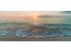 Tranquil beachfront view with a stunning sunset over the ocean waves at 6157 Midnight Pass Rd # E73, Sarasota, FL 34242
