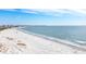 Scenic coastline view featuring soft white sand, ocean waves, and cityscape in the distance at 6157 Midnight Pass Rd # E73, Sarasota, FL 34242