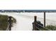 Sandy path leading to a vibrant beach full of beachgoers under colorful umbrellas. Great outdoor scenery at 6157 Midnight Pass Rd # E73, Sarasota, FL 34242