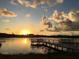 Waterfront with a wooden pier at sunset, offering a tranquil escape with calming waters and colorful skies at 6157 Midnight Pass Rd # E73, Sarasota, FL 34242