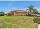 Tan home featuring a well manicured lawn, trimmed hedges, and a neatly kept garden at 635 Chipper Dr, Sun City Center, FL 33573