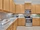 Kitchen with stainless steel appliances, wooden cabinets, and tile backsplash over granite countertops at 635 Chipper Dr, Sun City Center, FL 33573