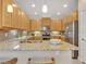 Bright kitchen featuring granite countertops, stainless steel appliances, tile backsplash, and pendant lighting at 635 Chipper Dr, Sun City Center, FL 33573