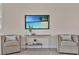 Living room with tile flooring, neutral armchairs, and a modern console table under a flat screen television at 635 Chipper Dr, Sun City Center, FL 33573