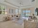 Bright living room with neutral tones, modern furnishings, and sliding doors to outdoor space at 635 Chipper Dr, Sun City Center, FL 33573