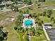 Aerial view of a sparkling community pool surrounded by lush landscaping and palm trees at 635 Chipper Dr, Sun City Center, FL 33573