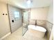 Modern bathroom with tub, glass-enclosed shower, and decorative tiling at 6524 Senegal Palm Way, Apollo Beach, FL 33572