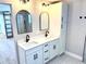 Bright bathroom featuring double vanity with marble countertops, black fixtures, and modern arched mirrors at 6524 Senegal Palm Way, Apollo Beach, FL 33572