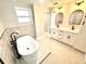 Beautiful bathroom with soaking tub, black fixtures, double vanity, and modern hexagon tile flooring at 6524 Senegal Palm Way, Apollo Beach, FL 33572