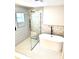 Modern bathroom with tub, glass-enclosed shower, and decorative tiling at 6524 Senegal Palm Way, Apollo Beach, FL 33572