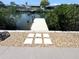 Waterfront property featuring a private wooden dock and paver pathway at 6524 Senegal Palm Way, Apollo Beach, FL 33572