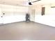 A look into the spacious garage with painted concrete floor, hot water tank and utility panel at 6524 Senegal Palm Way, Apollo Beach, FL 33572