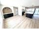 Open-concept living space with a modern kitchen island, arched buffet niche, and light wood floors at 6524 Senegal Palm Way, Apollo Beach, FL 33572
